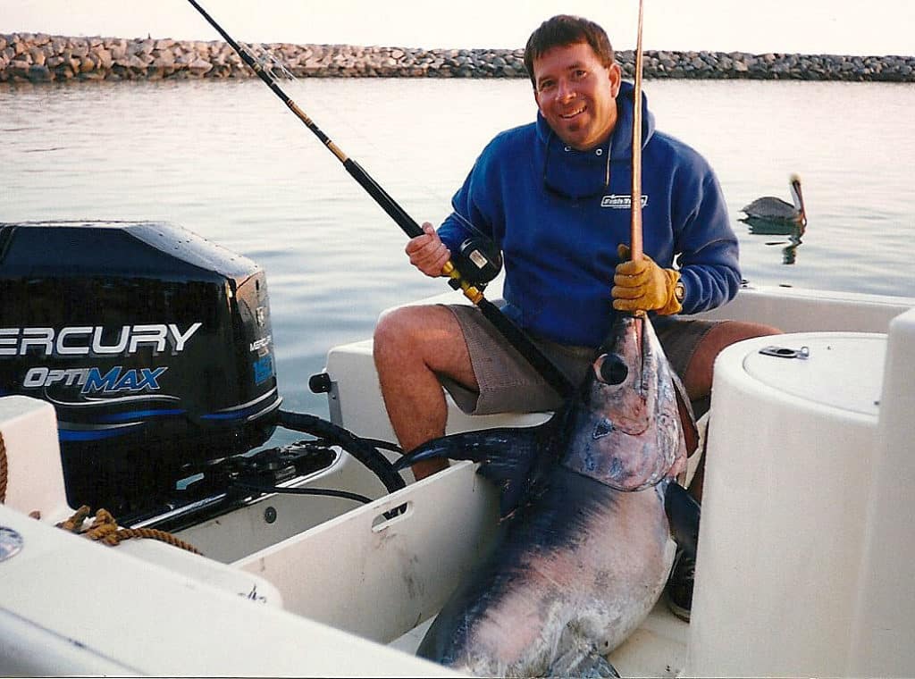 Fisherman holding swordfish caught on 20-foot center console fishing boat off Southern California