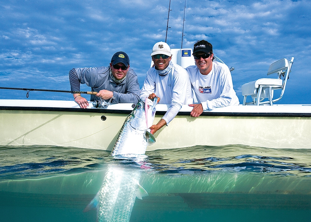 Saltwater fishermen in a fishing boat releasing a tarpon