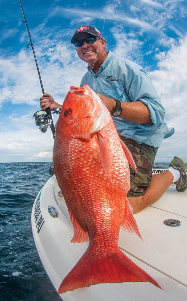 Angler holding red snapper fish caught deep sea fishing