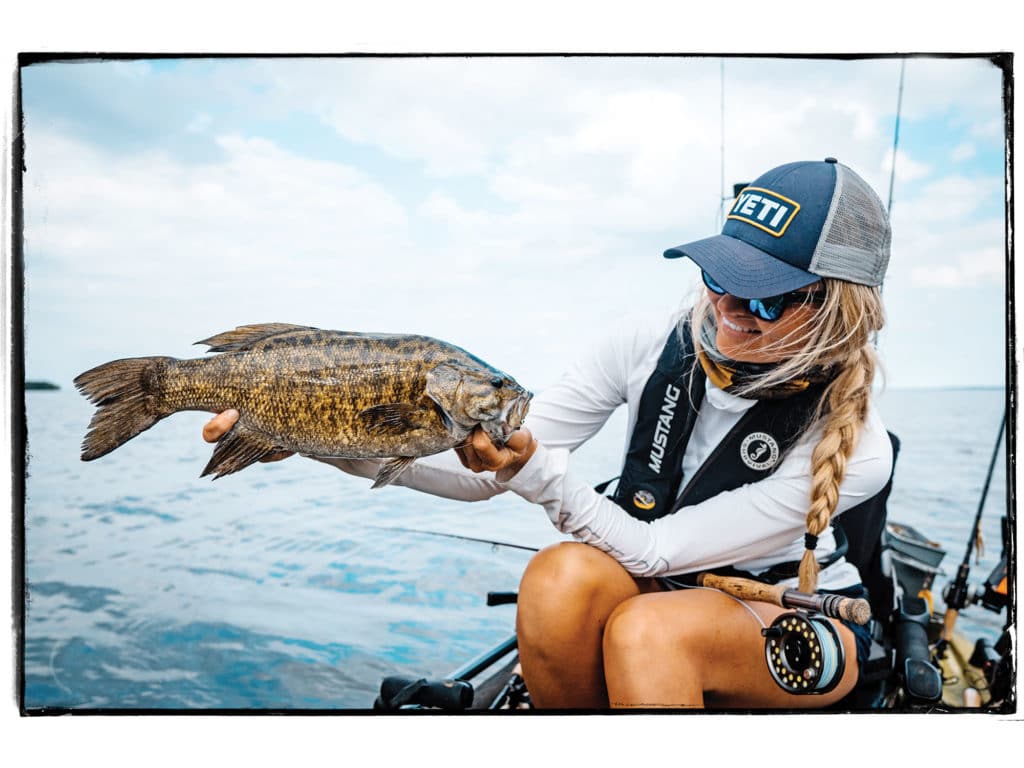 Kristine Fischer with a fish on a kayak