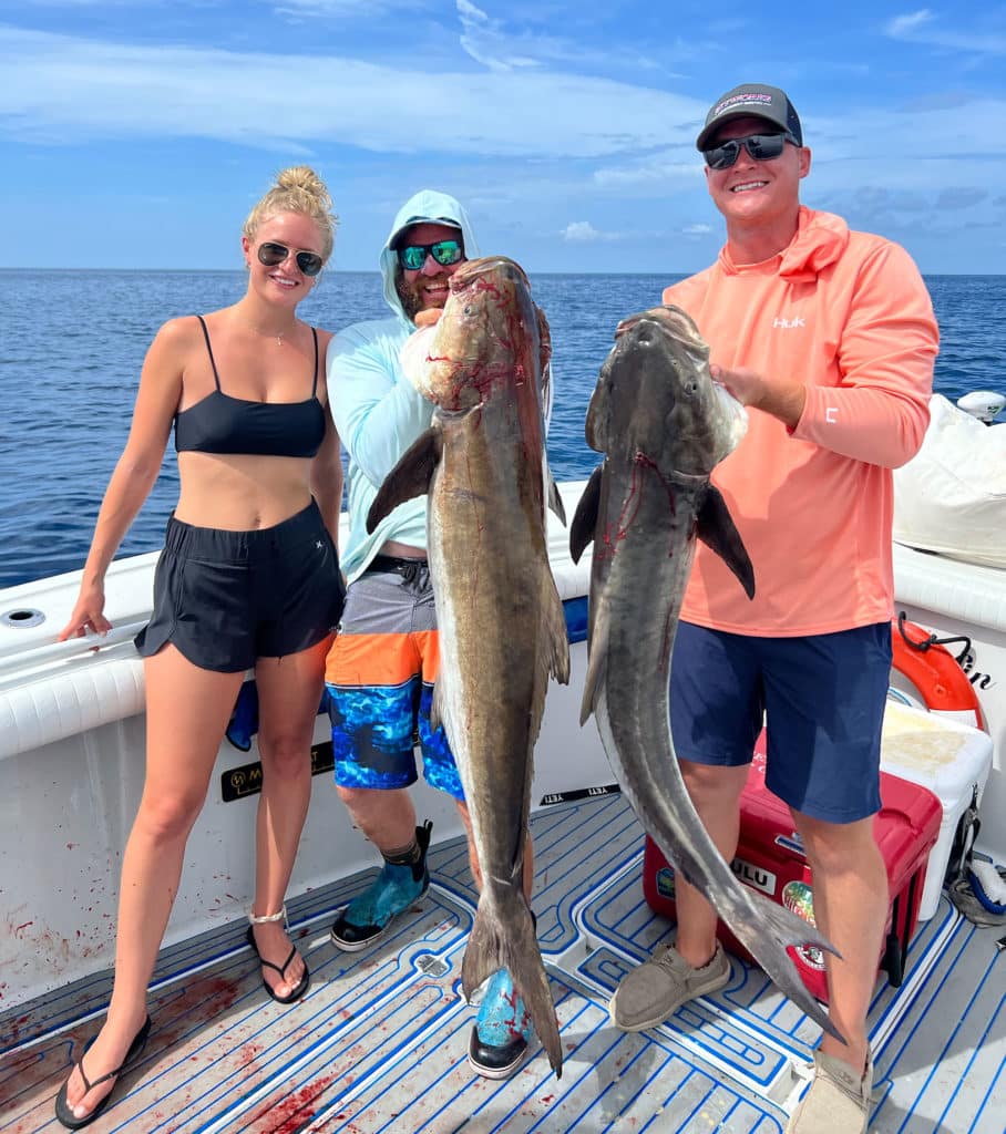 Anglers holding up cobia