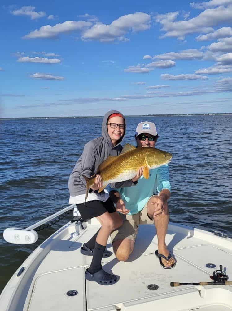Anglers holding up redfish