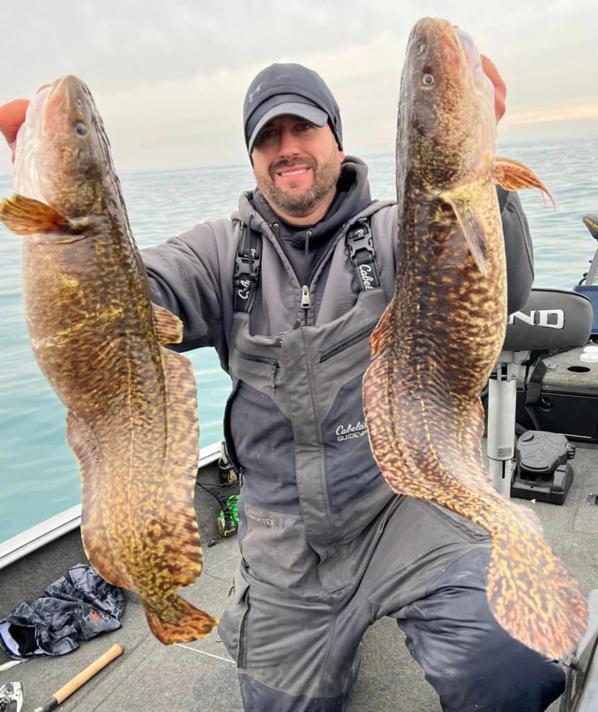 Scott Skafar holding up a pair of burbot