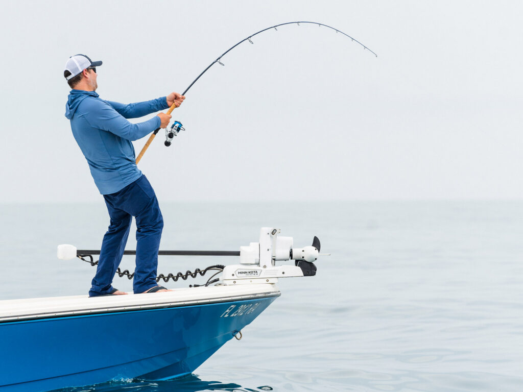 Man fighting a fish offshore.