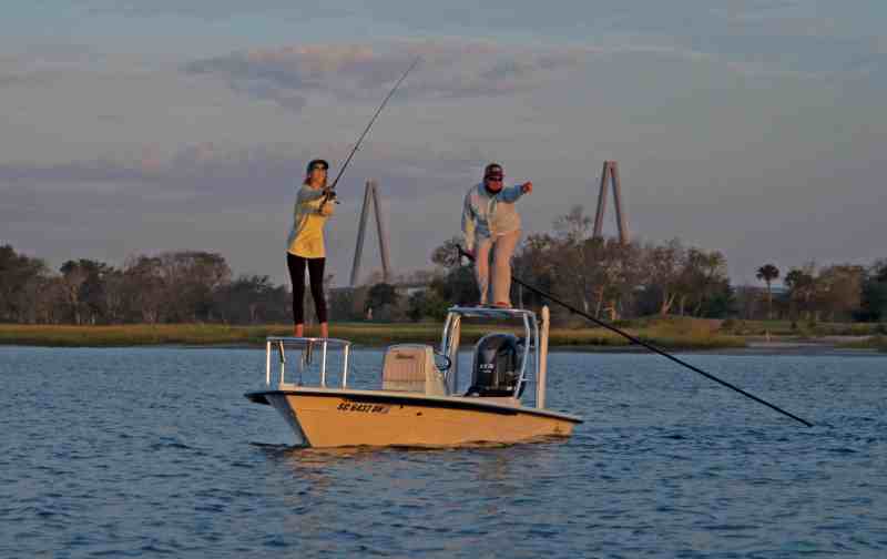 Anglers fishing from a skiff at sunset