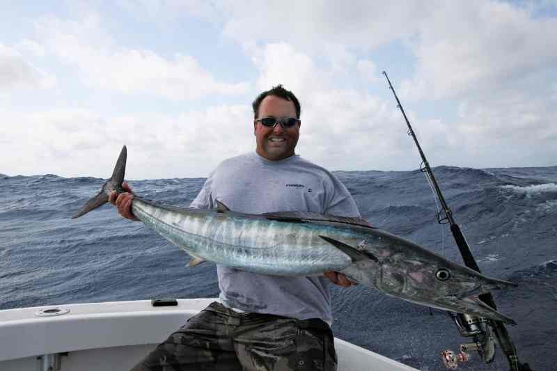 Holding wahoo up on board boat