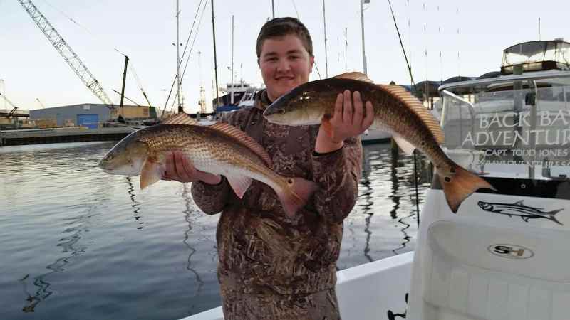 Angler holding redfish fishing Gulf of Mexico