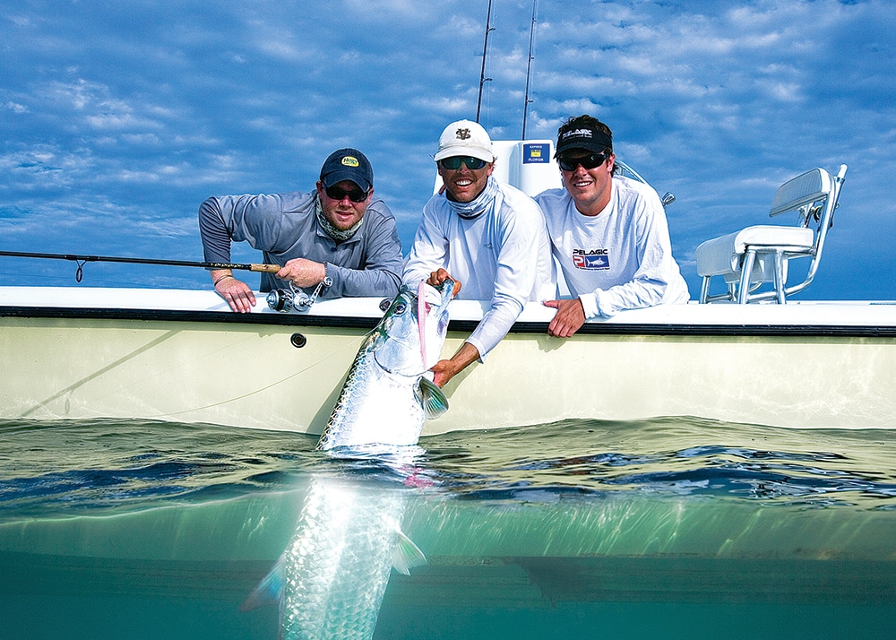 Saltwater fishermen in a fishing boat releasing a tarpon