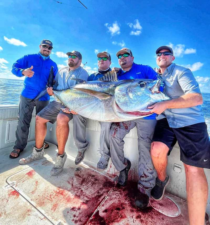Bigeye 1 A crew of five hold up a large bigeye tuna.