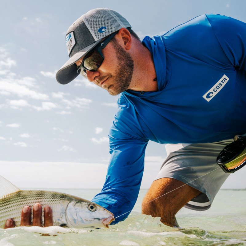 Angler wearing Costa Fly Line sunglasses and holding bonefish