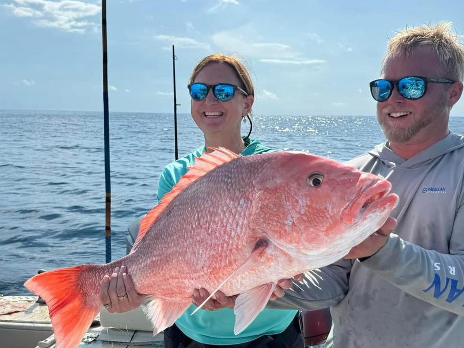 Two anglers hold a red snapper
