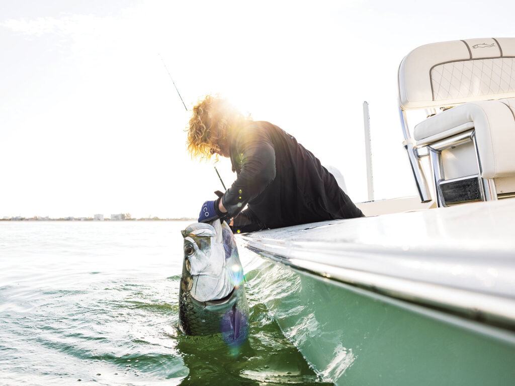 Tarpon next to a flats boat